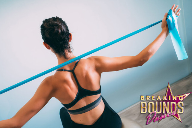 Woman stretching a resistance band behind her shoulders